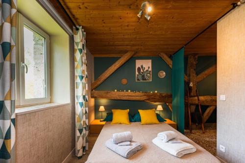 ein Schlafzimmer mit einem Bett mit zwei Handtüchern darauf in der Unterkunft Gîte l'Envol in Saint-Pierre-de-Clairac