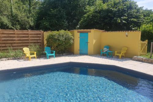 une cour avec une piscine entourée de chaises et une clôture dans l'établissement Gîte l'Envol, à Saint-Pierre-de-Clairac