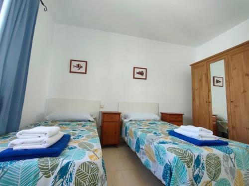 sypialnia z dwoma łóżkami i ręcznikami na nich w obiekcie Villa Rubicón Costa w mieście Playa Blanca
