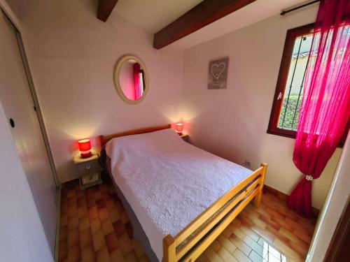 une chambre avec un lit et une fenêtre avec des rideaux rouges dans l'établissement Villa climatisée pour 6 pers., piscine, parking privé, proche plage et commerces - FR-1-607-123, au Cap d'Agde