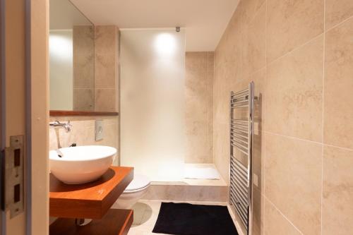 a bathroom with a white sink and a toilet at Durham City Luxury Apartment in Durham