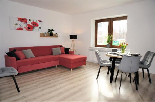 sala de estar con sofá rojo y mesa en Apartament Barskich, en Rzeszów