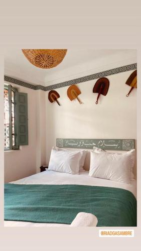 a bedroom with a large bed with a green blanket at Riad Gasämbre Touareg in Marrakech