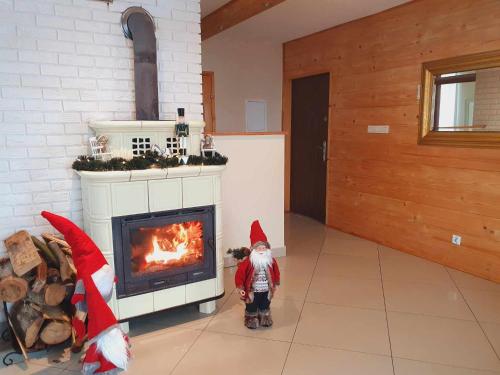 a child is standing in front of a fireplace at Solna Chata-dom na wyłączność Grota solna, balia, sauna, basen in Rajcza