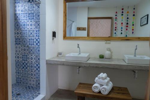 a bathroom with two sinks and a mirror and towels at Selina Montañita in Montañita