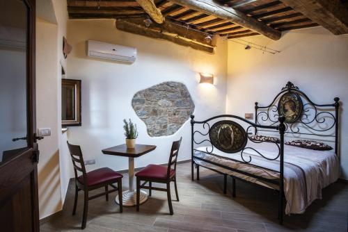 Schlafzimmer mit einem Bett, einem Tisch und Stühlen in der Unterkunft Antico Borgo Seggiano in Seggiano