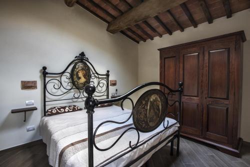 a bedroom with a bed and a wooden cabinet at Antico Borgo Seggiano in Seggiano