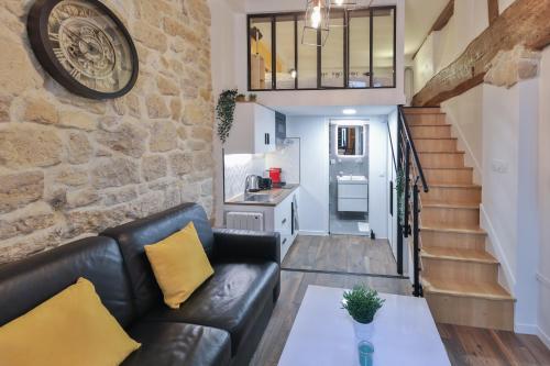 un salon avec un canapé en cuir et une cuisine dans l'établissement Modern Tasty Loft Saint Germain Latin Quarter, à Paris