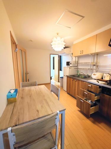 a large kitchen with a wooden table in a room at kaneshiro guest house in Tokyo