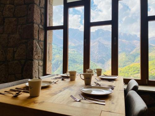 een houten tafel met borden en keukengerei met uitzicht bij Askireg Hotel 