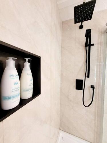 a bathroom with two bottles of soap and a shower at Spot Caché - Private Waterfront Cottage in Papineauville