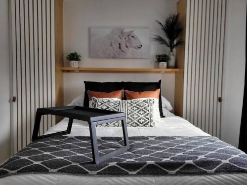 a bedroom with a bed with a table on it at Spot Caché - Private Waterfront Cottage in Papineauville