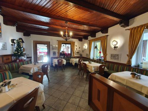 un restaurante con mesas y sillas en una habitación en Gasthof Zur Post en Ossiach
