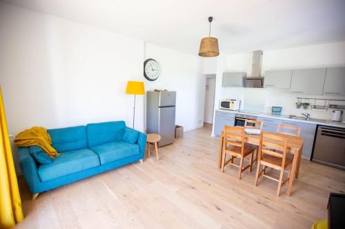 a living room with a blue couch and a table at Maison avec piscine entre garrigue et Cévennes in Cazilhac