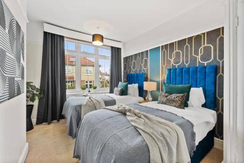 um quarto com 2 camas e uma janela em Stunning 4-bed - Garden - Sleeps 14 em Bristol