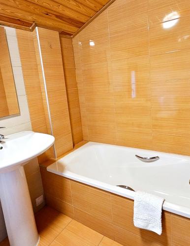 a bathroom with a bath tub and a sink at CASA COTIELLA RAÑIN in Rañín