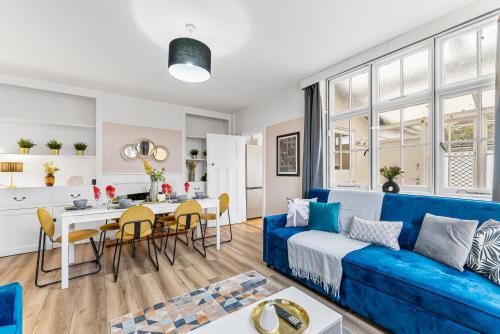 uma sala de estar com um sofá azul e uma mesa em Stunning 4-bed - Garden - Sleeps 14 em Bristol