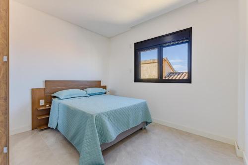 una camera con letto e finestra di Apartamento, Com Piscina - 350m da Praia de Bombas - 2 Suítes, 6 Pessoas a Bombinhas