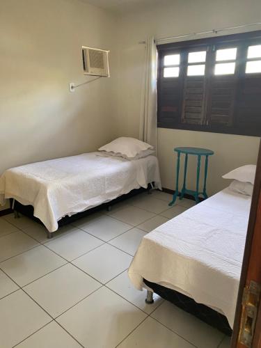 2 camas en una habitación con mesa y ventana en Casa na praia do francês, en Marechal Deodoro