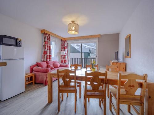 une cuisine et un salon avec une table et des chaises dans l'établissement Grand appartement 12 pers. à Peyragudes avec balcon - FR-1-695-8, à Germ