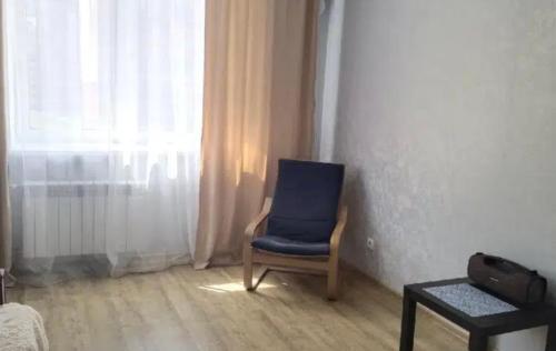 een blauwe stoel in een kamer met een raam bij VIP apart 560 in Tbilisi City