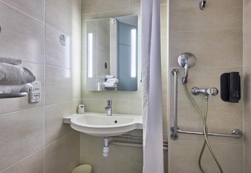 a bathroom with a sink and a shower at B&B HOTEL Caen Mémorial in Caen