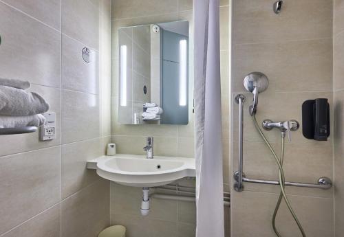 een badkamer met een wastafel en een douche bij B&B HOTEL Caen Mémorial in Caen