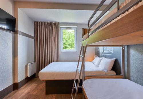a small room with two bunk beds and a window at B&B HOTEL Caen Mémorial in Caen