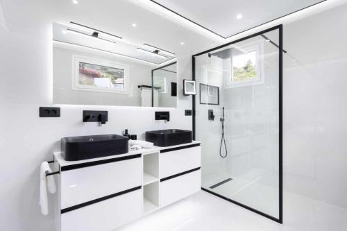 uma casa de banho branca com um lavatório e um chuveiro em Vivienda vacacional de lujo en el sauzal em Sauzal
