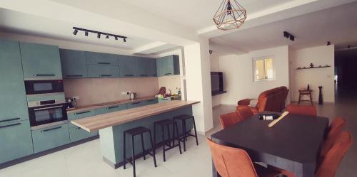 uma cozinha com armários azuis e uma mesa e cadeiras em Mgarr ix-Xini Holiday apartment em Xewkija