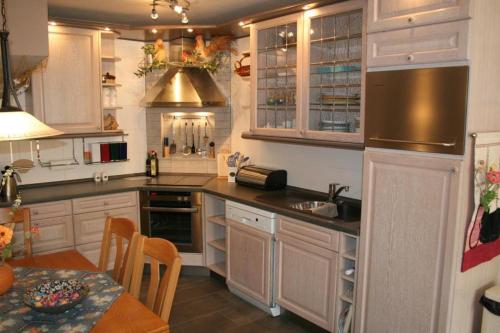 eine Küche mit weißen Schränken und einem Tisch mit einem Esszimmer in der Unterkunft Heggerank 23B* in Nieuwvliet