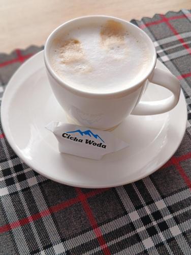 a cup of coffee on a plate on a table at Cicha Woda 300 m od Gorący Potok i Termy Szaflary in Szaflary