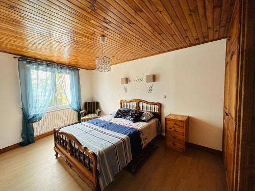 1 dormitorio con cama y techo de madera en Gîte du Lavoir, en Moncaup