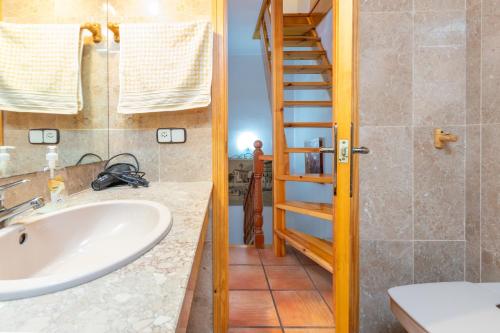 uma casa de banho com um lavatório e uma escada em Casa Natalio em Platja d'Aro