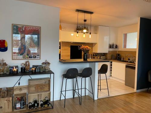 une cuisine avec un comptoir et des tabourets dans une pièce dans l'établissement Appartement La Madeleine - Proximité Lille, à Lille
