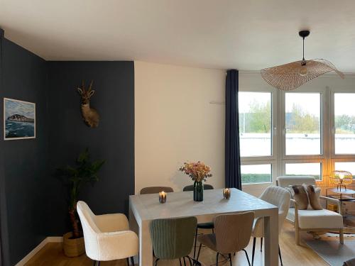 une salle à manger avec une table et des chaises blanches dans l'établissement Appartement La Madeleine - Proximité Lille, à Lille