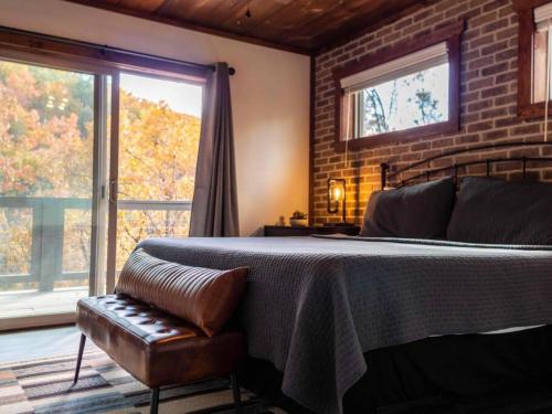 1 dormitorio con 1 cama, 1 silla y ventanas en Escape to Elegance by Ghosal Luxury Lodging, en Sevierville