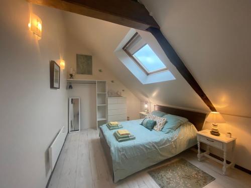 1 dormitorio en el ático con 1 cama y tragaluz en Gîte Le Chêne doré, en La Boussac