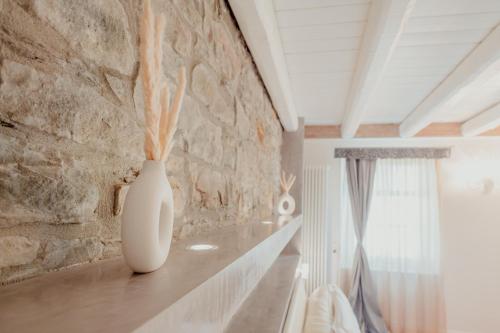 Aphrodite Luxury penthouse with Jacuzzi في ترييستي: وجود مزهرية بيضاء على طاولة في غرفة