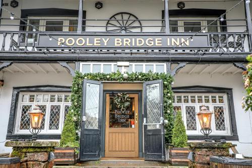 a door to a poole bridge inn with a sign above it at The Pooley Bridge Inn in Pooley Bridge