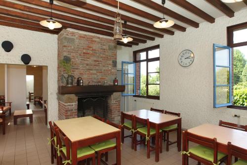 un restaurant avec des tables et des chaises et une cheminée dans l'établissement Les Pommes d'Or, à Marly-Gomont