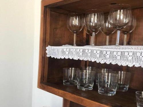 un gruppo di bicchieri da vino seduti su uno scaffale di Cozy Apartment in Torrenova in a delightful area a Torrenova