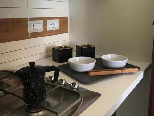 un bancone della cucina con due ciotole bianche e un lavandino di Cozy Apartment in Torrenova in a delightful area a Torrenova