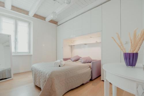 um quarto branco com uma cama e um sofá em Aphrodite Luxury penthouse with Jacuzzi em Trieste