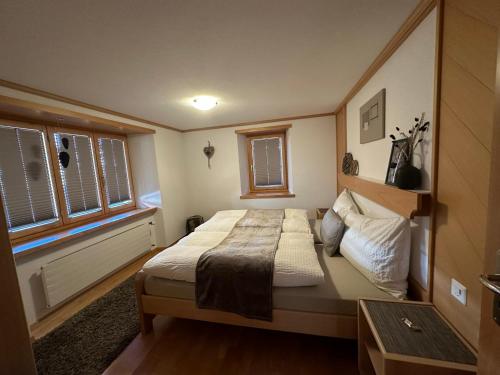 - une chambre avec un grand lit et 2 fenêtres dans l'établissement Apartment Bergfreude, à Saas-Grund