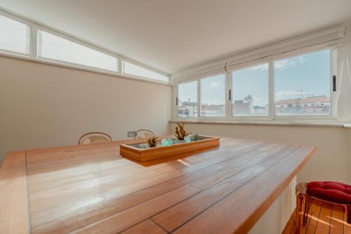 a large room with a wooden table and large windows at Aphrodite Luxury APT with Jacuzzi in Trieste