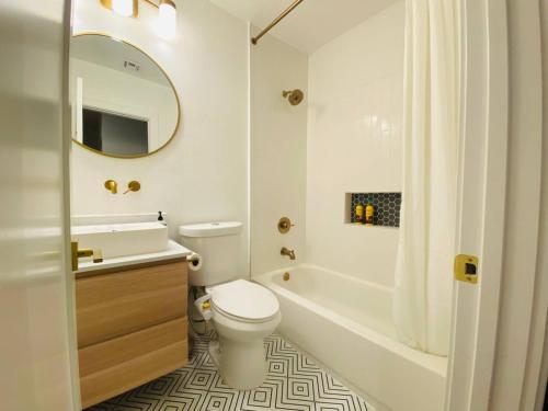 een badkamer met een toilet, een bad en een wastafel bij Charming 3 BR Home Near SoFi and LAX - 65th in Los Angeles