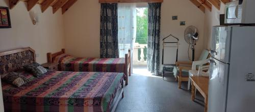 a hotel room with a bed and a refrigerator at La Pergola, Sauce Monte Hermoso in Monte Hermoso