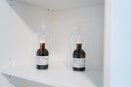 two bottles of wine on a shelf with candles at ZENtrahome - Zentral Outlet Business SmartTV Balkon in Metzingen