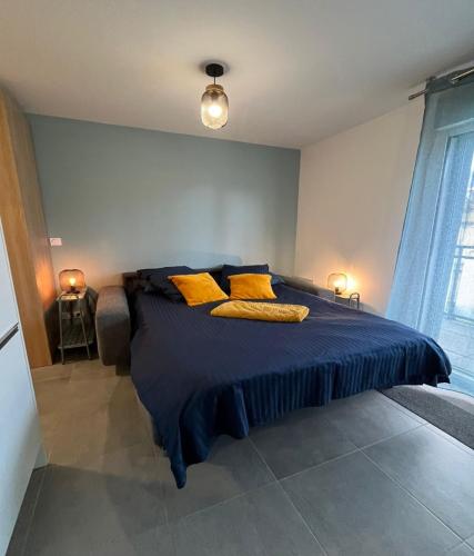 - une chambre avec un lit bleu et des oreillers jaunes dans l'établissement Studio Hermine neuf pour 2 personnes au cœur de St, à Saint-Malo